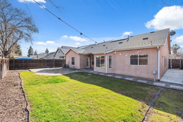 rear view of house featuring cooling unit, a yard, and a patio area