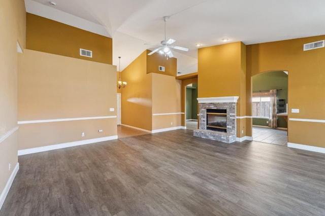 unfurnished living room with high vaulted ceiling, ceiling fan with notable chandelier, and hardwood / wood-style floors