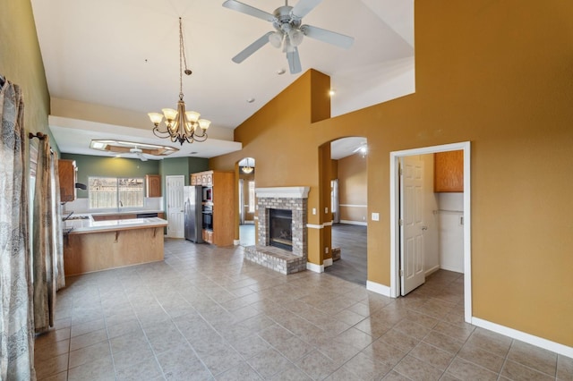 kitchen with pendant lighting, light tile patterned floors, stainless steel fridge, ceiling fan, and a fireplace