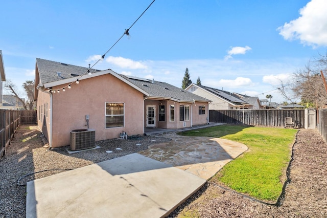 back of property with a yard, cooling unit, and a patio area