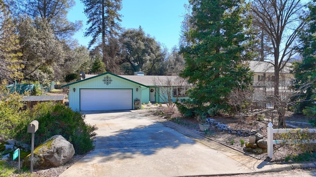 view of front facade with driveway, a garage, and fence