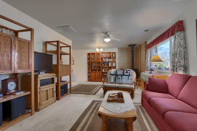 living area featuring visible vents, light colored carpet, a wood stove, and ceiling fan