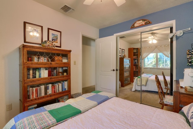 bedroom with visible vents, a ceiling fan, a closet, and carpet flooring