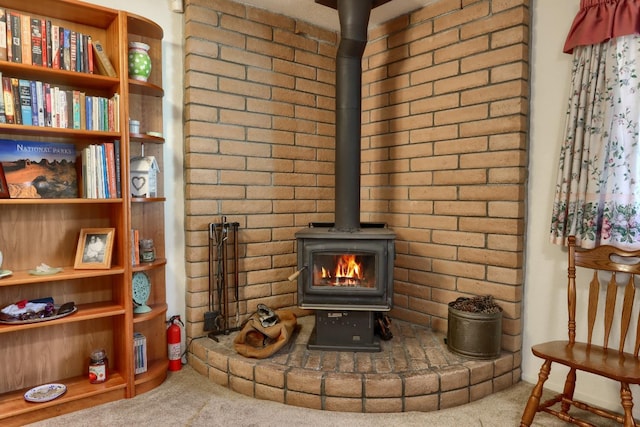 room details featuring a wood stove, a fire extinguisher, and carpet floors