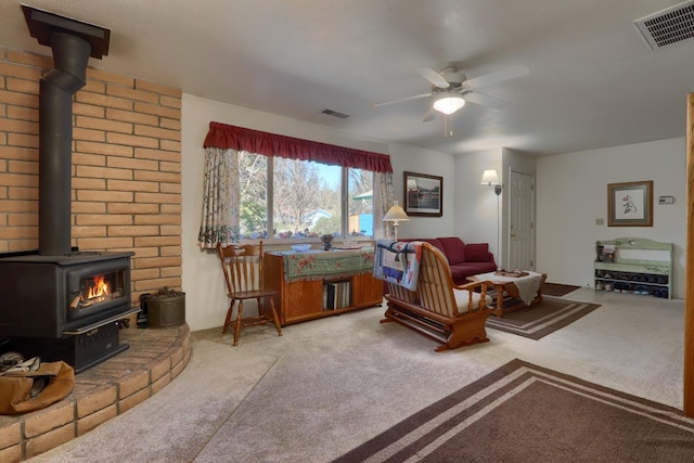 living area featuring visible vents, light carpet, a ceiling fan, and a wood stove