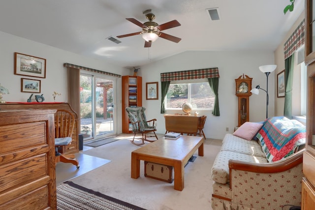 living area with visible vents, lofted ceiling, light colored carpet, and a healthy amount of sunlight