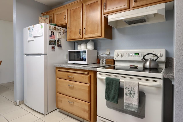 kitchen with white appliances, light tile patterned floors, brown cabinets, and under cabinet range hood