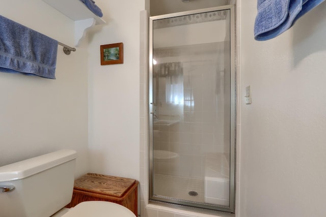 full bath featuring a shower stall and toilet