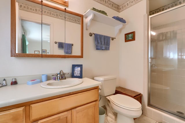 full bath with a stall shower, toilet, and vanity