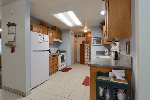 kitchen featuring dark countertops, under cabinet range hood, brown cabinets, white appliances, and a sink