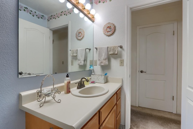 bathroom with vanity and a textured wall