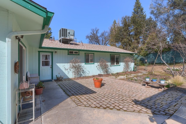 rear view of property featuring a patio area, central AC unit, and fence