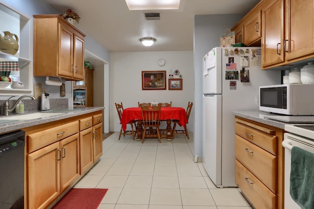 kitchen with visible vents, light countertops, light tile patterned flooring, white appliances, and a sink