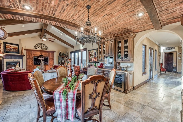 dining room featuring vaulted ceiling with beams, a notable chandelier, brick ceiling, and beverage cooler