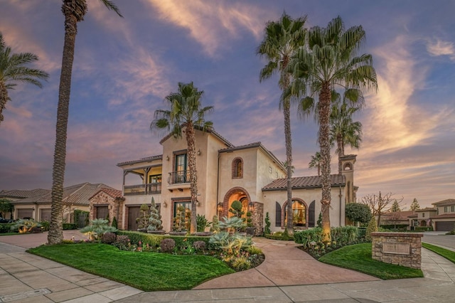 mediterranean / spanish home featuring a balcony and a lawn