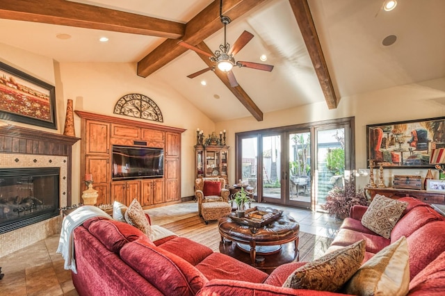 living room with a tiled fireplace, ceiling fan, french doors, and lofted ceiling with beams