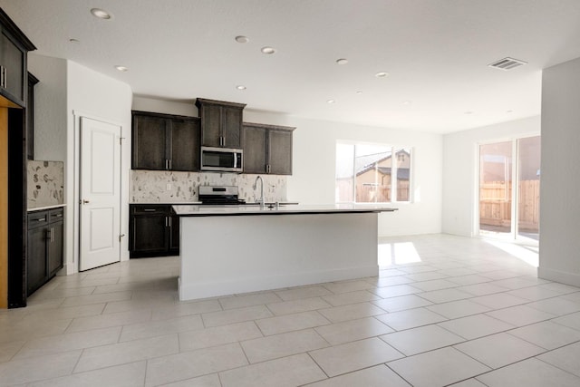 661 Lucas Ave S, Madera, CA 93636 - kitchen with visible vents, stainless steel appliances, tasteful backsplash, an island with sink, and open floor plan