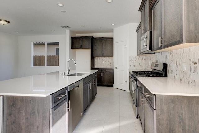 661 Lucas Ave S, Madera, CA 93636 - kitchen featuring a sink, appliances with stainless steel finishes, visible vents, decorative backsplash, and dark brown cabinets