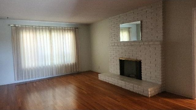 unfurnished living room featuring hardwood / wood-style flooring and a fireplace