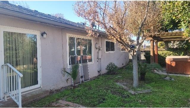 view of home's exterior with a yard and a pergola