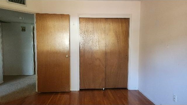 unfurnished bedroom featuring dark hardwood / wood-style flooring and a closet