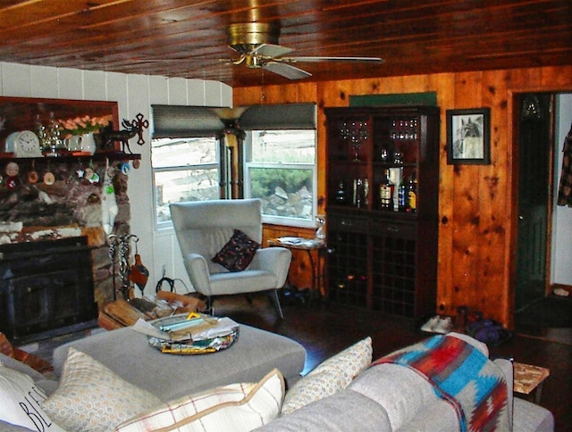 living room featuring ceiling fan, wood ceiling, wooden walls, and a fireplace