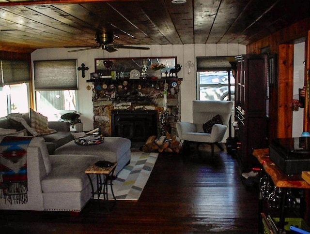 living room featuring hardwood / wood-style flooring, ceiling fan, wooden walls, a fireplace, and wooden ceiling