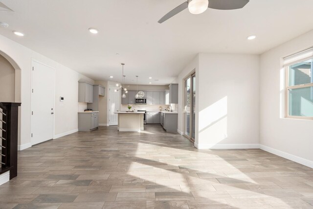 unfurnished living room featuring sink and ceiling fan