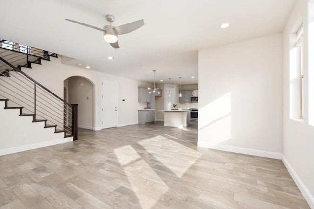 unfurnished living room featuring ceiling fan