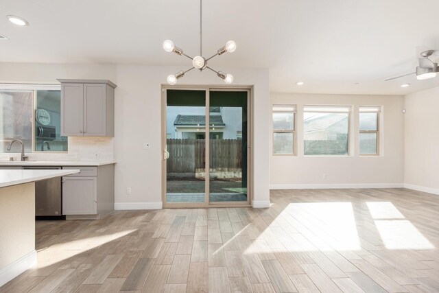 kitchen featuring pendant lighting, sink, light hardwood / wood-style floors, and gray cabinetry