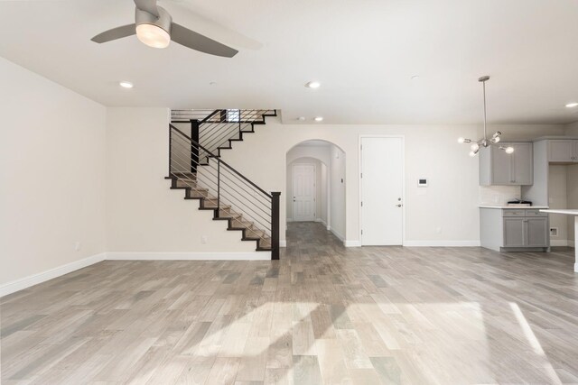 unfurnished living room featuring ceiling fan and light hardwood / wood-style flooring