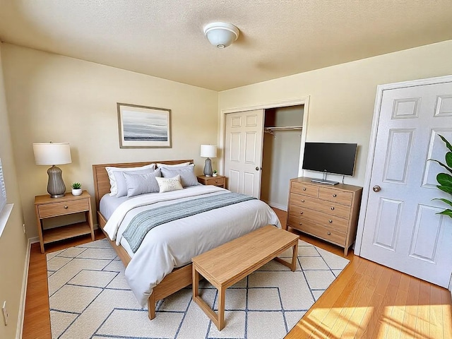 bedroom featuring a textured ceiling, a closet, and light wood-style floors