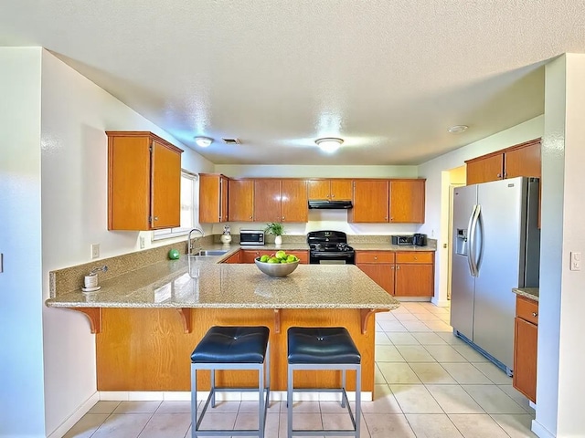 kitchen featuring stainless steel refrigerator with ice dispenser, a sink, black range with gas cooktop, a peninsula, and extractor fan