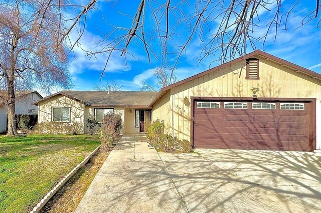 ranch-style house with a garage and a front lawn