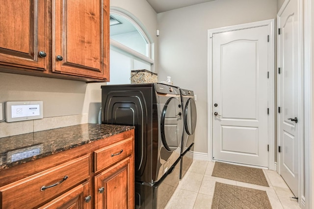 laundry area with cabinets, separate washer and dryer, and light tile patterned floors