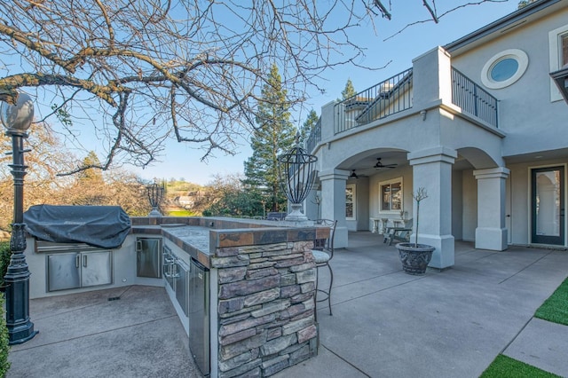 view of patio featuring ceiling fan, a balcony, exterior kitchen, and area for grilling