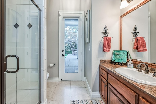 bathroom with tile patterned flooring, vanity, toilet, and walk in shower