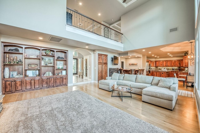 living room with an inviting chandelier and light wood-type flooring