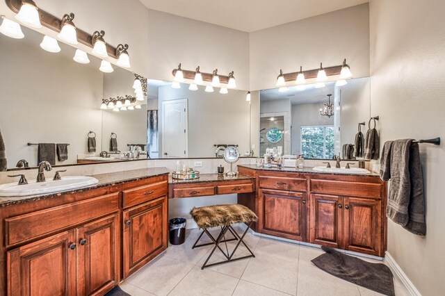 bathroom with tile patterned flooring, vanity, and a chandelier