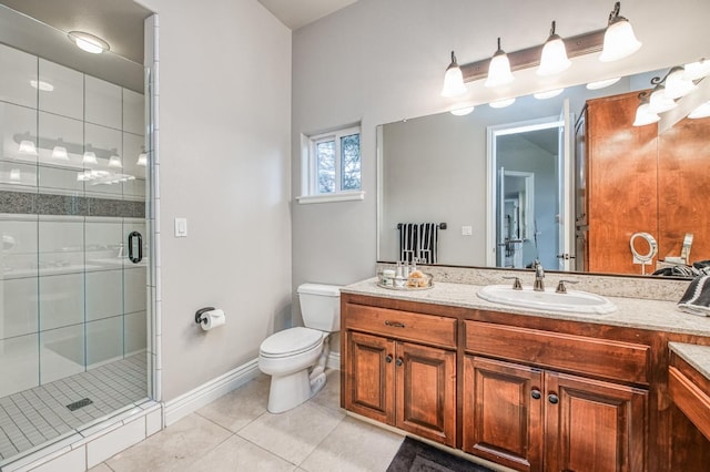 bathroom with tile patterned flooring, vanity, a shower with door, and toilet