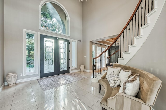 tiled foyer featuring a healthy amount of sunlight and a high ceiling