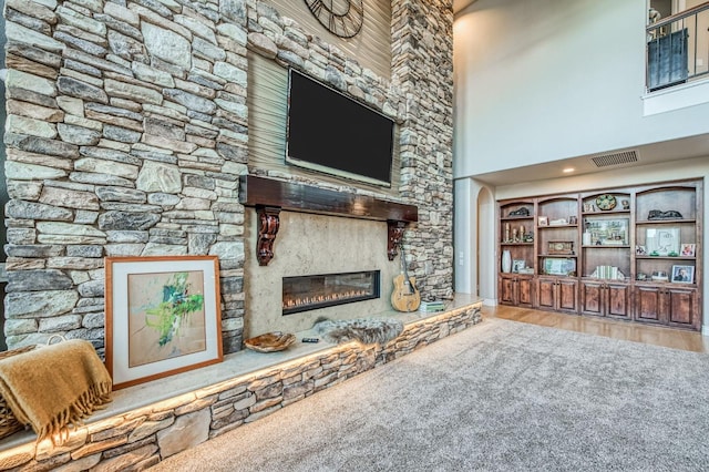 living room featuring a fireplace, wood-type flooring, and a high ceiling