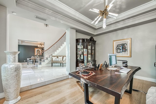 dining room featuring crown molding, hardwood / wood-style flooring, a raised ceiling, and a chandelier