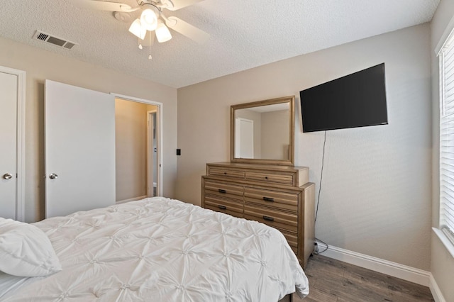 bedroom with hardwood / wood-style flooring, a textured ceiling, and ceiling fan