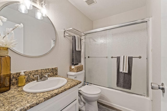 full bath with bath / shower combo with glass door, vanity, visible vents, and toilet