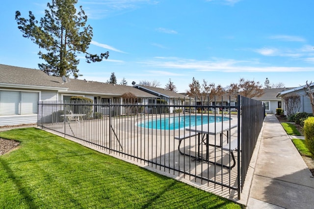 view of pool with a patio, a yard, a fenced in pool, and fence