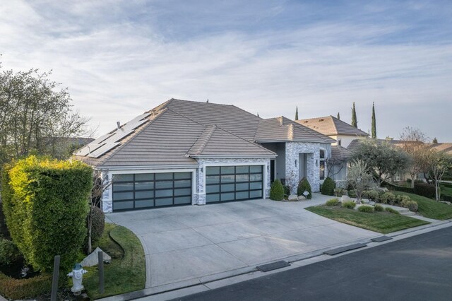 view of front of house featuring a garage and solar panels