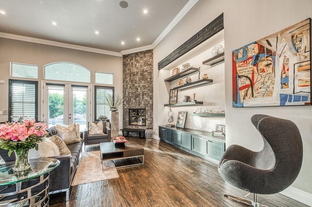 living room featuring dark wood-type flooring, crown molding, a stone fireplace, and french doors