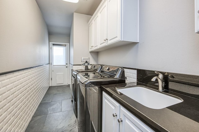 clothes washing area featuring cabinets, separate washer and dryer, and sink