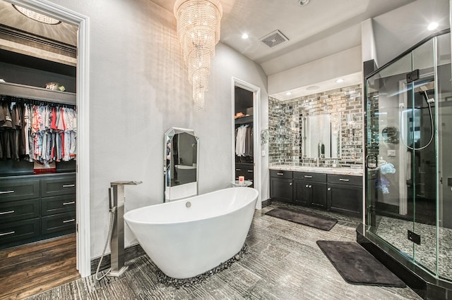 bathroom with hardwood / wood-style flooring, vanity, independent shower and bath, and vaulted ceiling